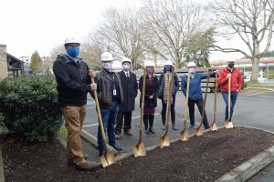 Outside photo of seven adult individuals all holding golden shovels, breaking ground at Together Center, February 2021.
